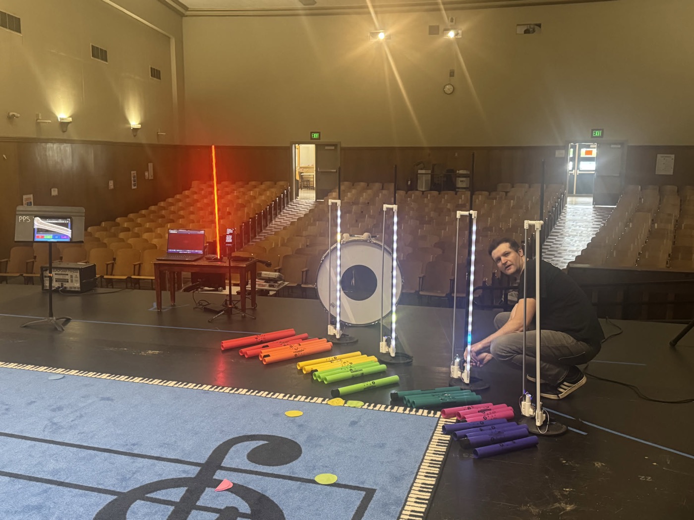Tuned percussion being placed in sequence along the printed staff, the room still empty.