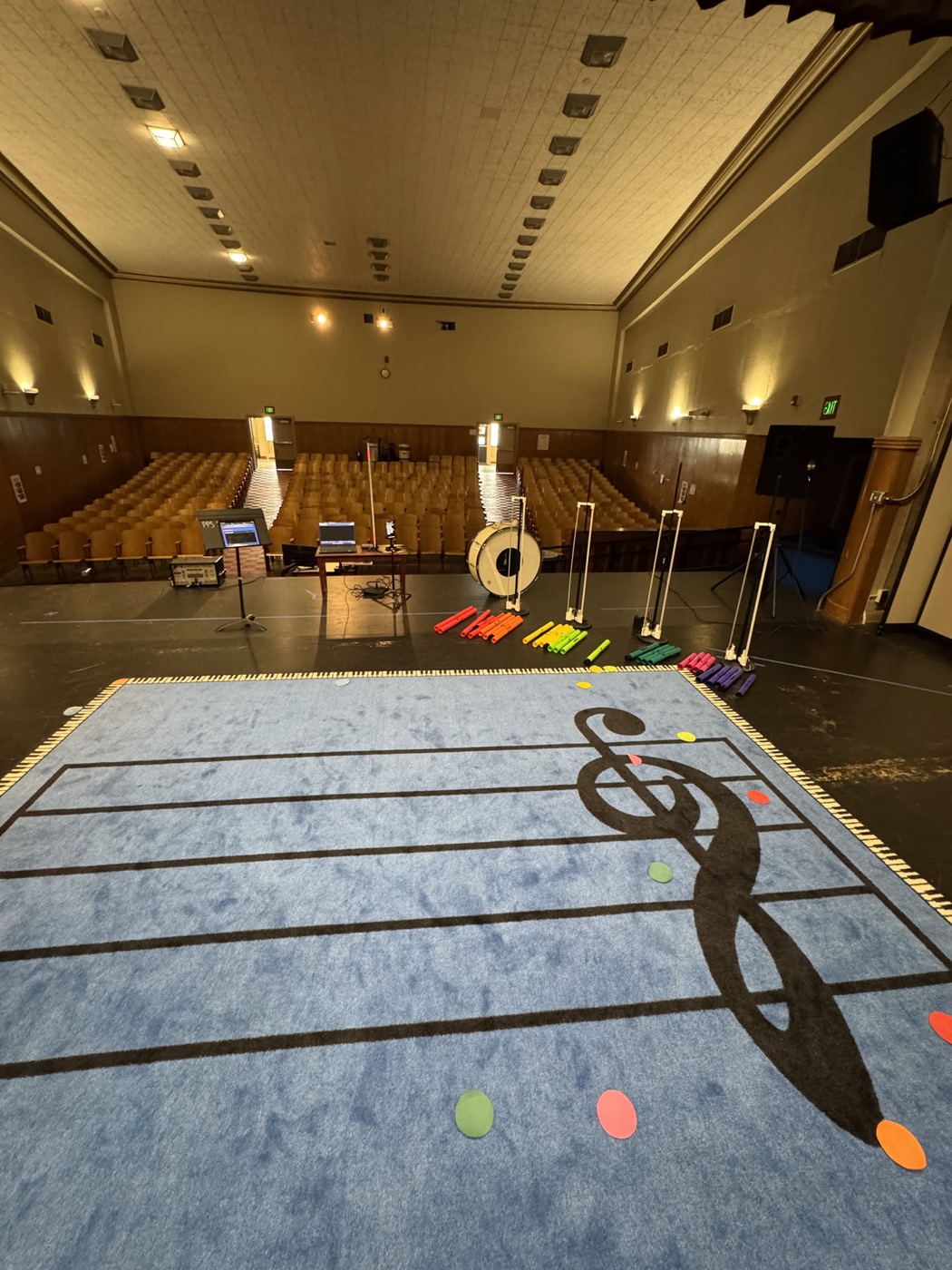 A close view of the floor mat, five staff lines and a large treble clef printed across it.
